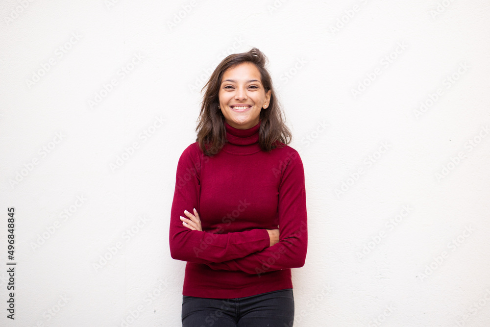 young smiling woman with arms crossed by isolated white background young smiling woman with arms crossed by isolated white background