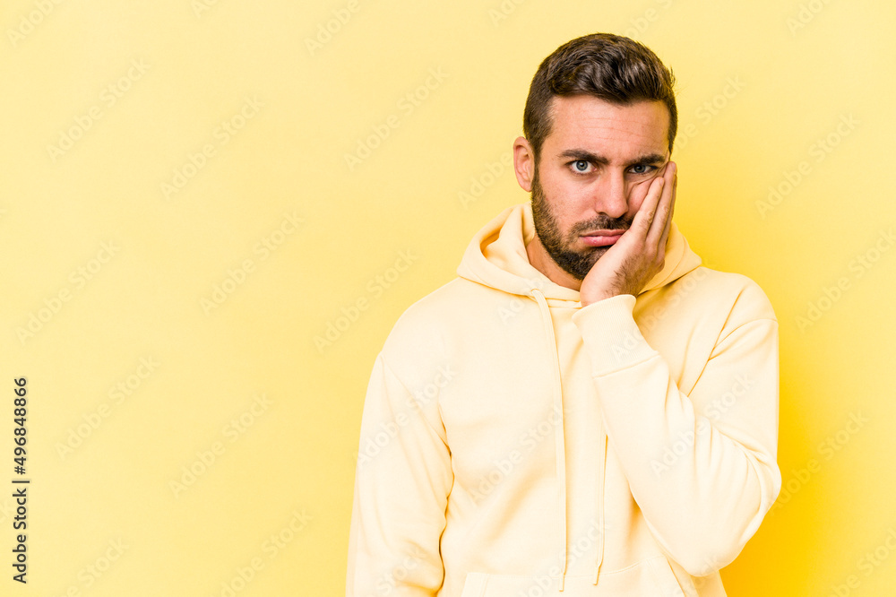 Young caucasian man isolated on yellow background who feels sad and pensive, looking at copy space. Young caucasian man isolated on yellow background who feels sad and pensive, looking at copy space.