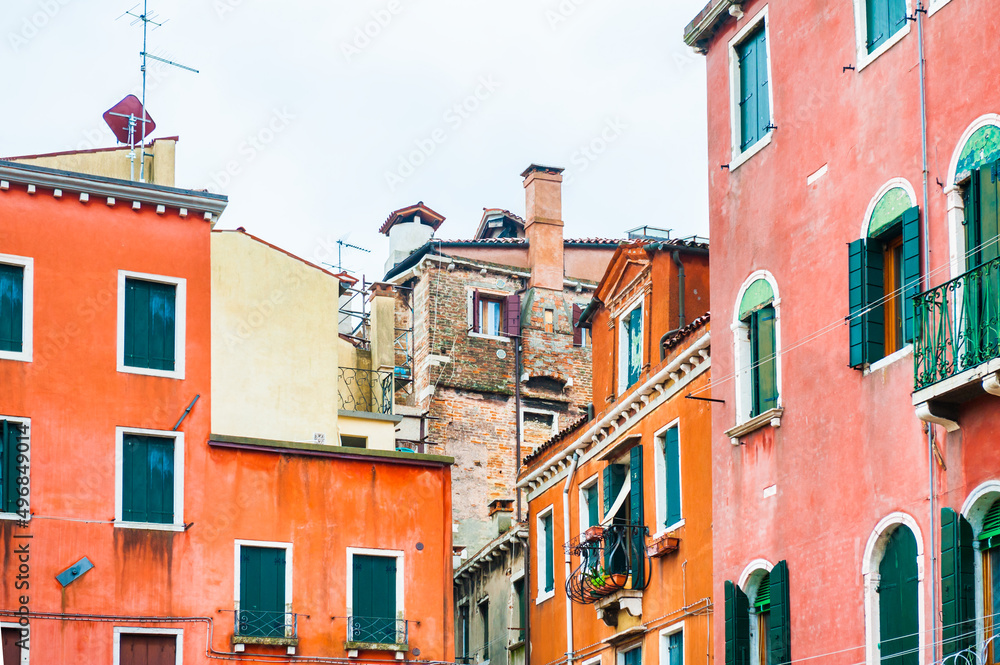 Colorful architecture in Venice, Italy. Red facades of the houses and windows with green shutters