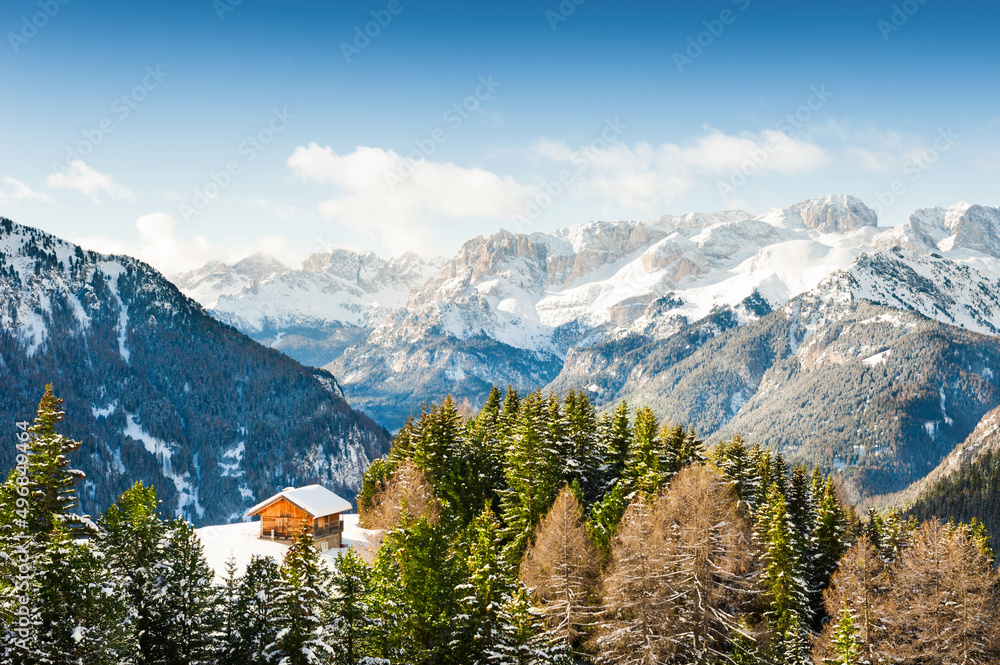 Wooden house in Dolomite Alps, Val di Fassa, Italy. Winter landscape