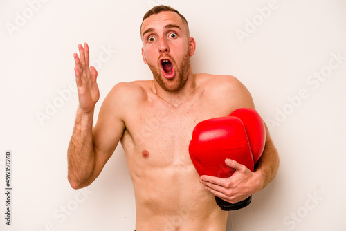 Young caucasian man doing boxing isolated on white background surprised and shocked.