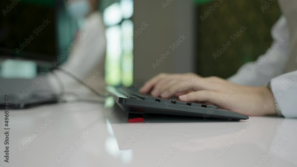 Close up, Zoom out the hand of a woman typing keyboard on counter check-in at the airport. Close up, Zoom out the hand of a woman typing keyboard on counter check-in at the airport.
