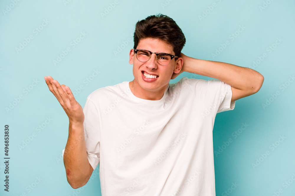 Young caucasian man isolated on blue background screaming with rage. Young caucasian man isolated on blue background screaming with rage.