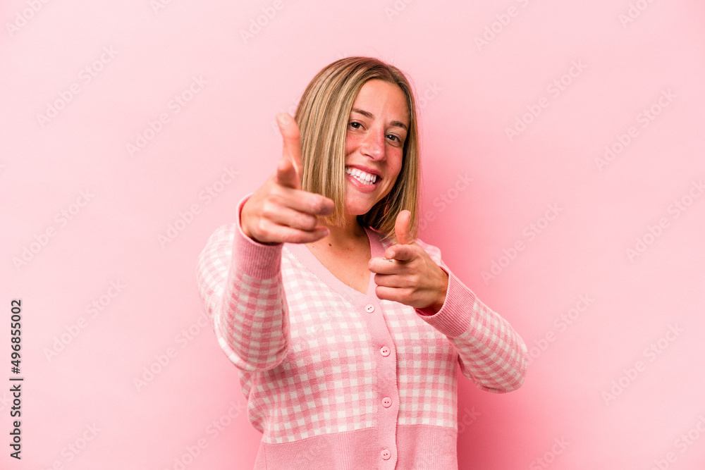 Young caucasian woman isolated on pink background cheerful smiles pointing to front. Young caucasian woman isolated on pink background cheerful smiles pointing to front.