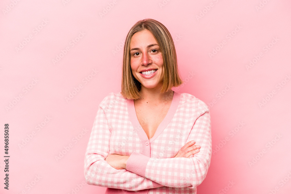 Young caucasian woman isolated on pink background who feels confident, crossing arms with determination. Young caucasian woman isolated on pink background who feels confident, crossing arms with determination.