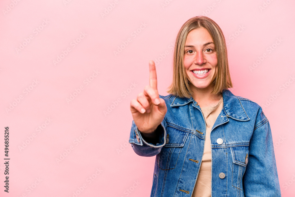 Young caucasian woman isolated on pink background showing number one with finger. Young caucasian woman isolated on pink background showing number one with finger.