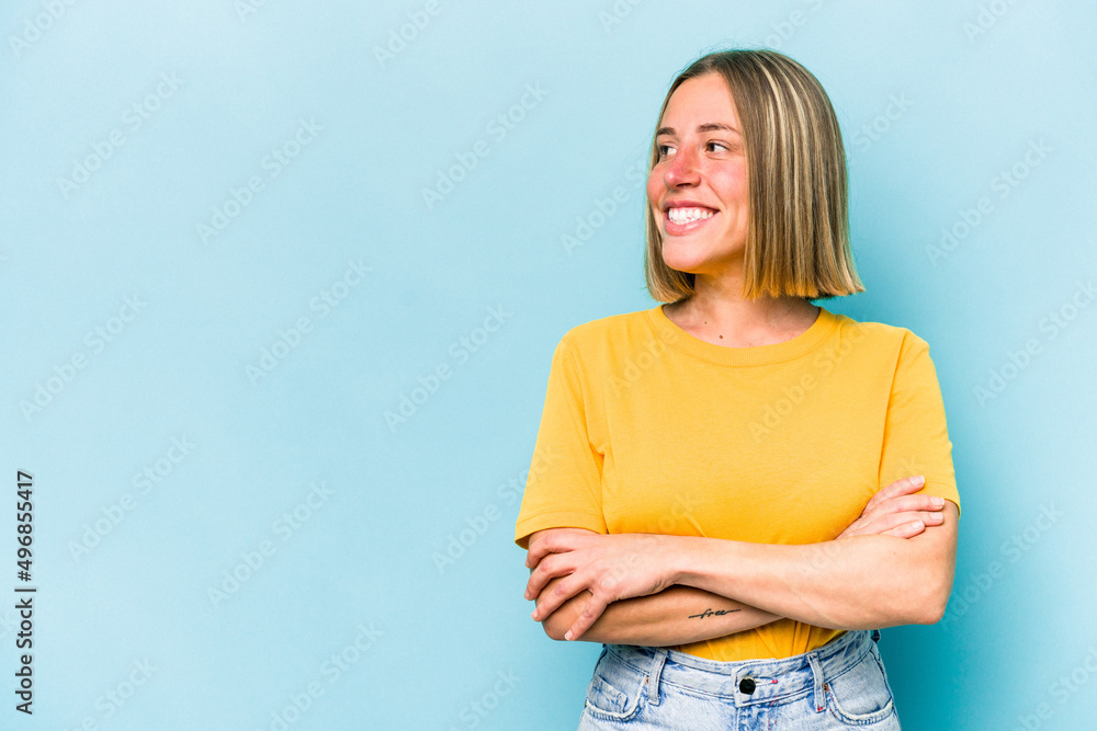 Young caucasian woman isolated on blue background smiling confident with crossed arms. Young caucasian woman isolated on blue background smiling confident with crossed arms.