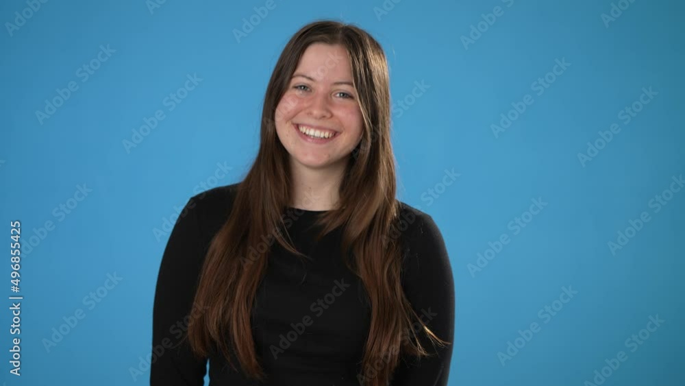 Portrait of happy smiling young brunette woman 20s thumbs up, wears black shirt isolated on plain blue background copy space studio portrait. People emotions lifestyle concept Portrait of happy smiling young brunette woman 20s thumbs up, wears black shirt isolated on plain blue background copy space studio portrait. People emotions lifestyle concept