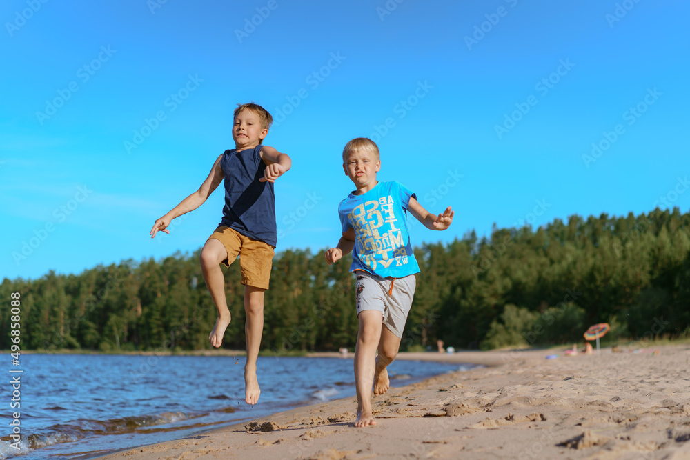 kids running alone esa side. Pine forest on background. Happy childhood concept. kids running alone esa side. Pine forest on background. Happy childhood concept.