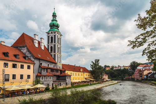 Buildings on the banks of the Vltava River with the Church of St. Yoshta on a sunny summer day. Cesky Krumlov, Czech Republic photo