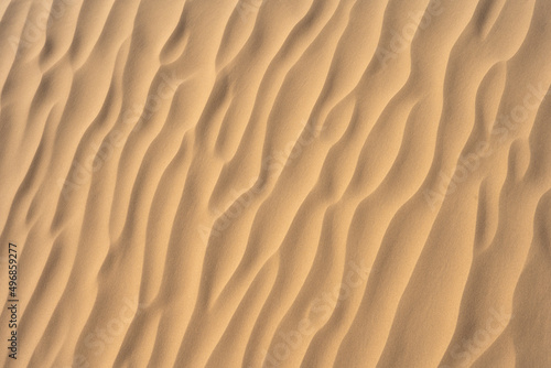 Fotografie View of a beach sand texture with asymmetrical lines and and sunlight on it