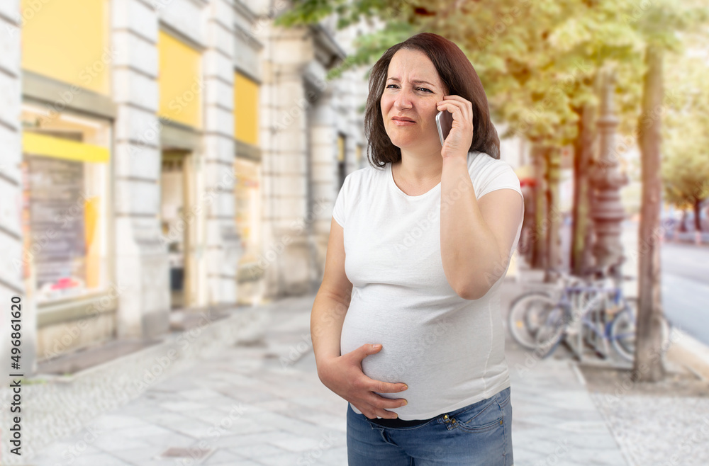 Shot of a painful pregnant woman calling medical assistance in the city Shot of a painful pregnant woman calling medical assistance in the city