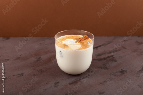 Salep or Sahlab in glass on brown background. Salep - Turkish traditional winter drink. Selective focus, copy space photo