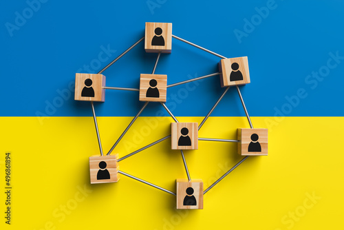 Wooden blocks with people icon on the background of Ukraine flag. Concept of unity and solidarity of people. 3d rendering.