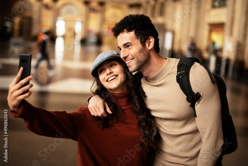 Beautiful couple at railway station waiting for the train. Young woman and man waiting to board a train..