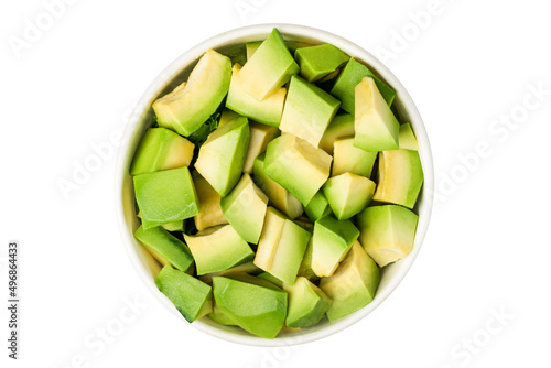 A bowl of avocado slices on a gray textured  background. Top view.