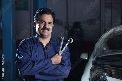 Man with a mustache when building a car with metal tools in hand in Navneet Sharma, India photo