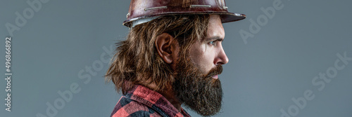 Builder in hard hat, foreman or repairman in the helmet. Building, industry, technology - builder concept. Bearded man worker with beard in building helmet or hard hat. Man builders, industry