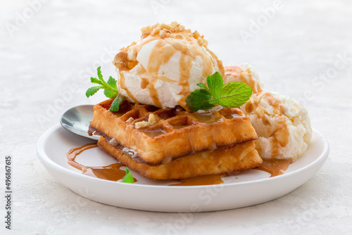Konstfotografi ice cream with waffles, caramel syrup and fresh mint on a white dish