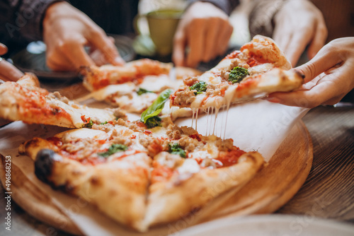 Canvas Print Three firends together eating pizza in a cafe