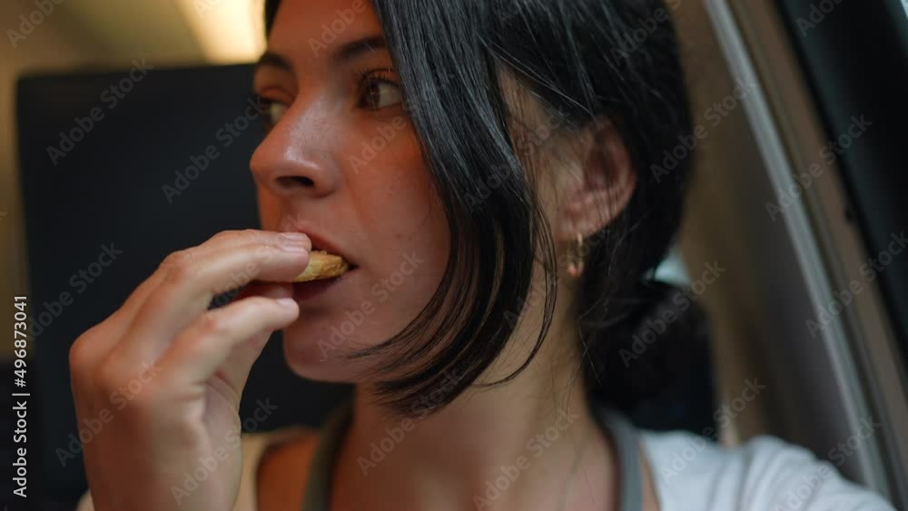 Passenger woman eating cookie while traveling on comute Passenger woman eating cookie while traveling on comute