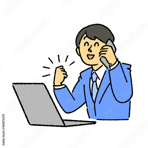 パソコンを見ながらガッツポーズで電話するビジネスマン