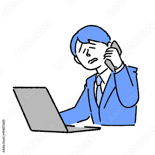 パソコンを見ながらクレーム処理の電話をするビジネスマン