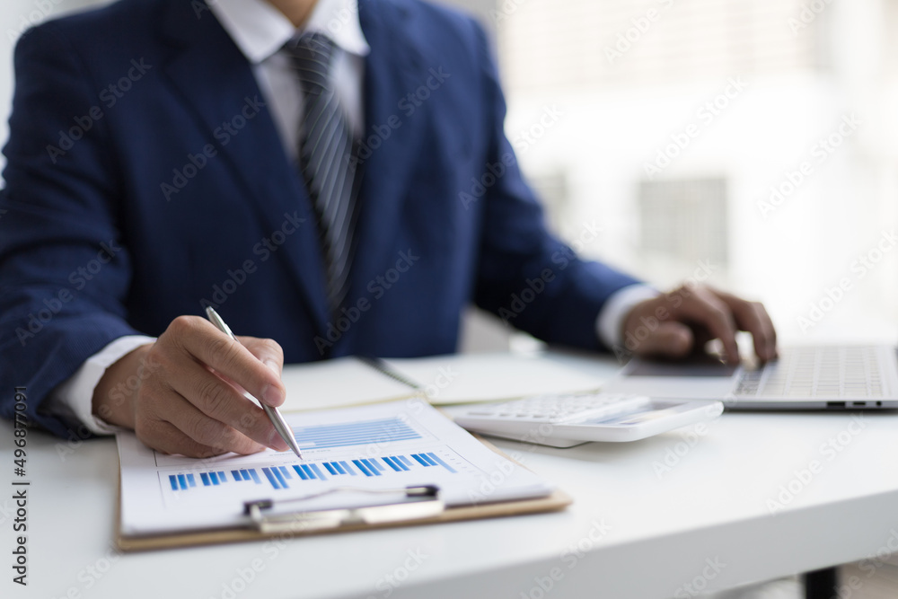 Accountant, businessman or banker points to financial reports and financial planning strategy analysis. Concept of financial advisor, auditing, banking and accounting. Accountant, businessman or banker points to financial reports and financial planning strategy analysis. Concept of financial advisor, auditing, banking and accounting.