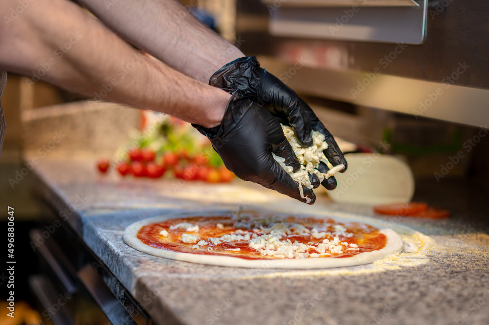 Chef baking pizza in the italian pizzeria - obrazy, fototapety, plakaty 