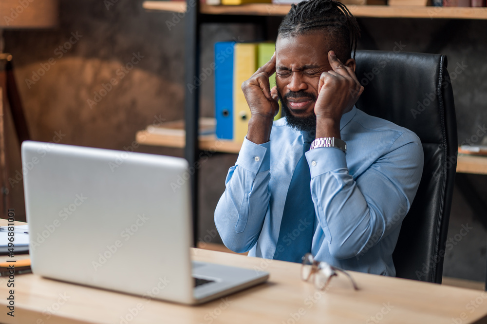 Male entrepreneur suffering from a temporal headache Male entrepreneur suffering from a temporal headache