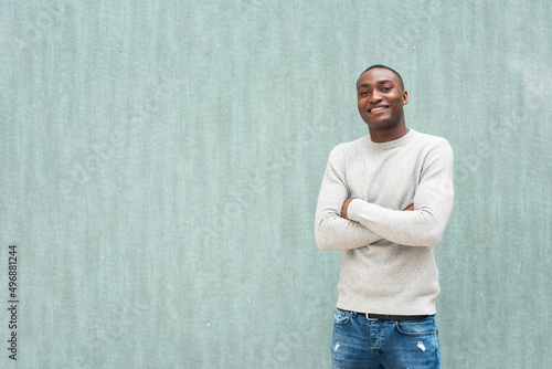 smiling African american man with arms crossed against green background