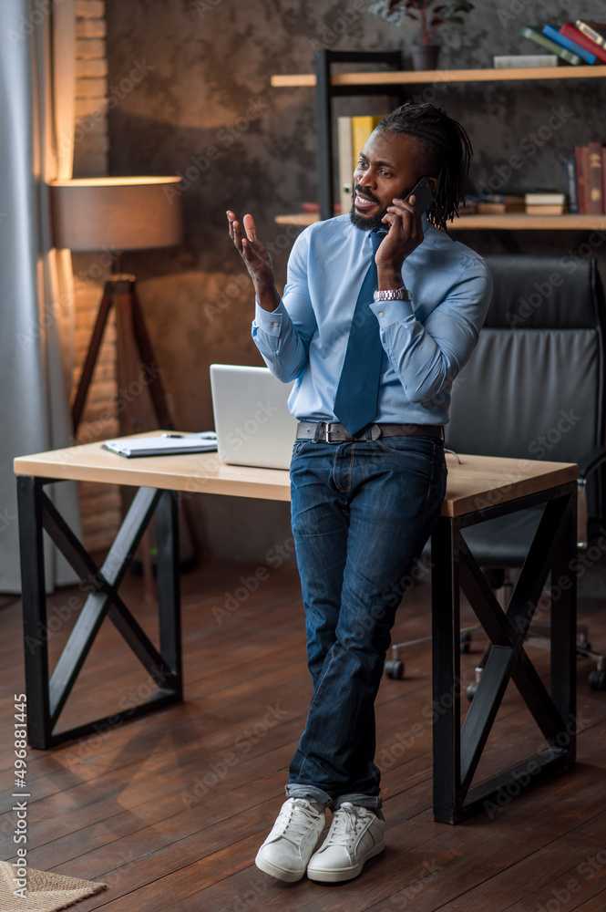 Serious young businessman talking on the smartphone Serious young businessman talking on the smartphone