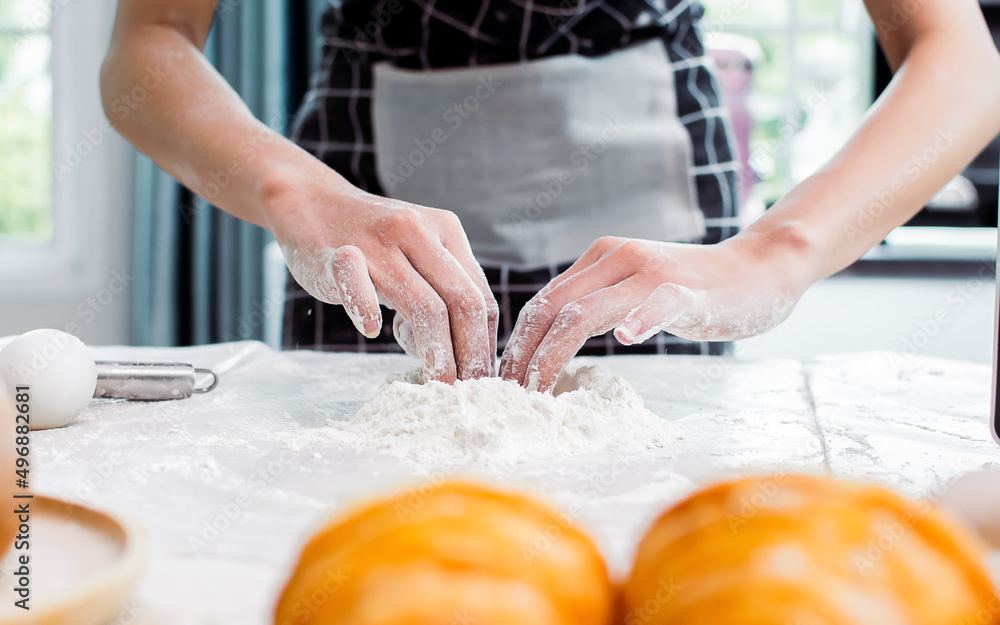 Selective focus and close up on hands teaching, showing and threshing dough flour with egg inside to make pie for serving on table in kitchen at home. Restaurant, Bakery, Hobby and Lifestyle concept. Selective focus and close up on hands teaching, showing and threshing dough flour with egg inside to make pie for serving on table in kitchen at home. Restaurant, Bakery, Hobby and Lifestyle concept.