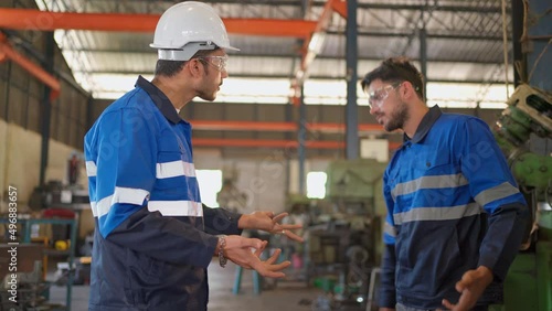 Angry engineer boss scolding young engineers for their mistake standing in the CNC manufacturing factory. Negative boss yelling employee during work. Man throw helmet on the ground and walk away
