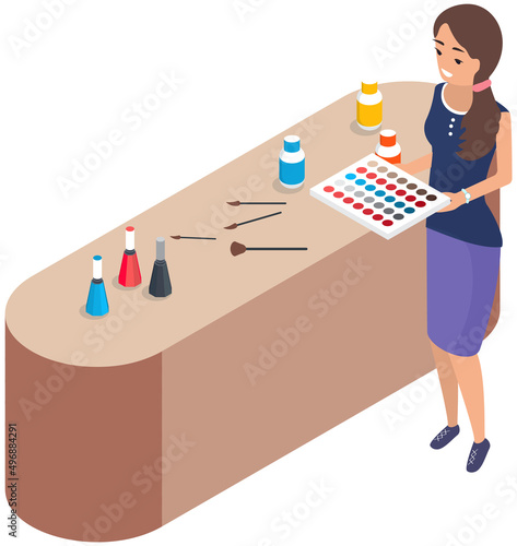 Lady standing near table with set of makeup tools and holding eyeshadow palette. Decorative cosmetics for face. Stand with elements of cosmetics for face beauty. Woman working as makeup artist