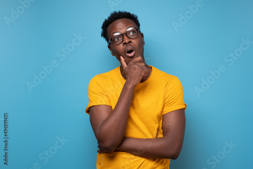 Young african american man with glasses looking up confident