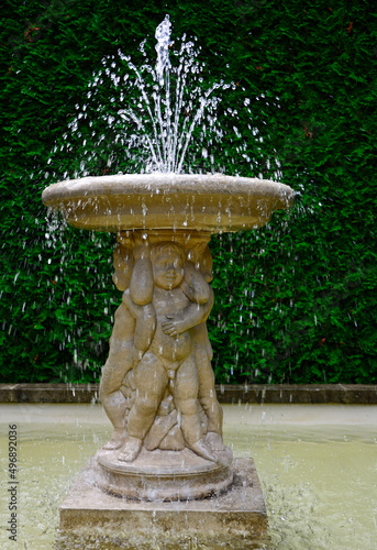 kamienna fontanna ogorodowa i cherubiny,  beautiful fountain in the garden, water gushing from the garden fountain	 photo