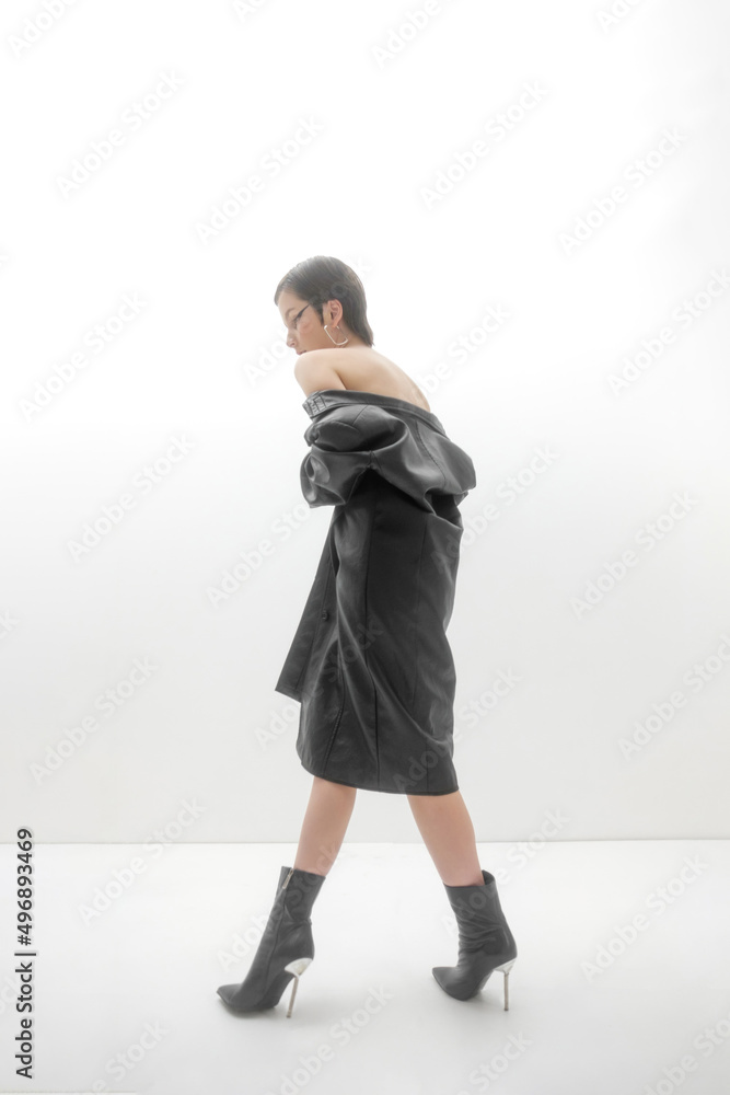 Fashion photo shoot in studio, on white background. Young beautiful woman emotionally and dramatically poses in black vintage cloak on a naked body. Short brown hair, large black eye arrows. Fashion photo shoot in studio, on white background. Young beautiful woman emotionally and dramatically poses in black vintage cloak on a naked body. Short brown hair, large black eye arrows.