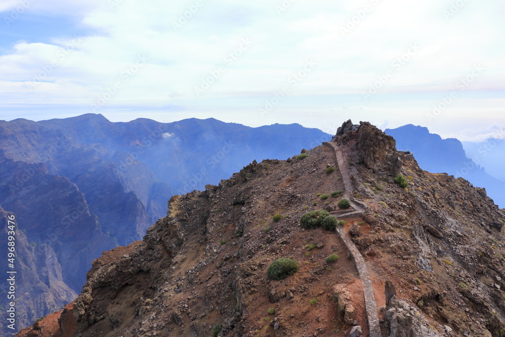Impressive panoramic landscape of clouds and volcanic mountains from the top of the Roque de los Muchachos viewpoint, on the island of La Palma, Canary Islands, Spain