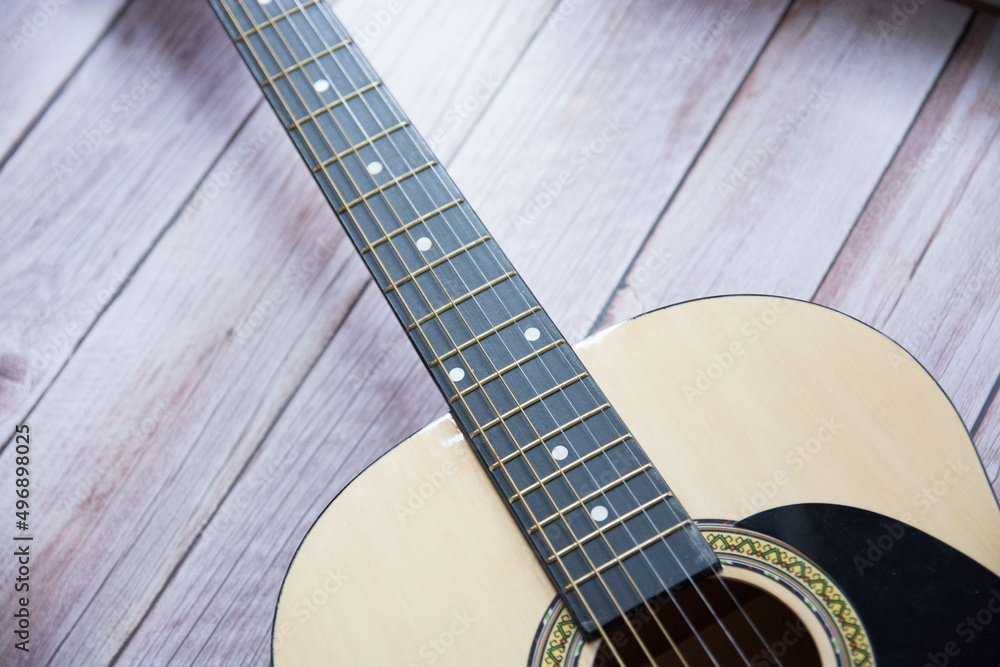 Obraz premium Preciosa guitarra acústica sobre fondo de madera
