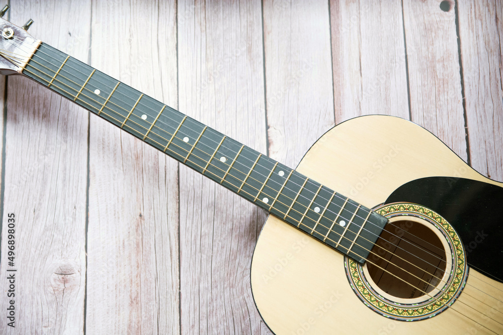 Obraz premium Preciosa guitarra acústica sobre fondo de madera