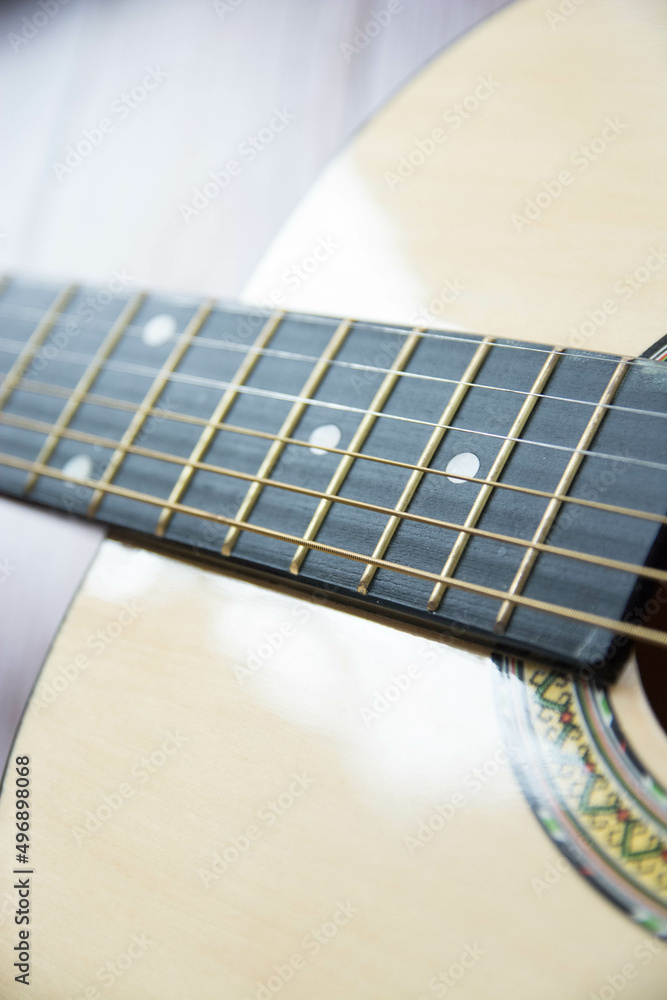 Obraz premium Preciosa guitarra acústica sobre fondo de madera