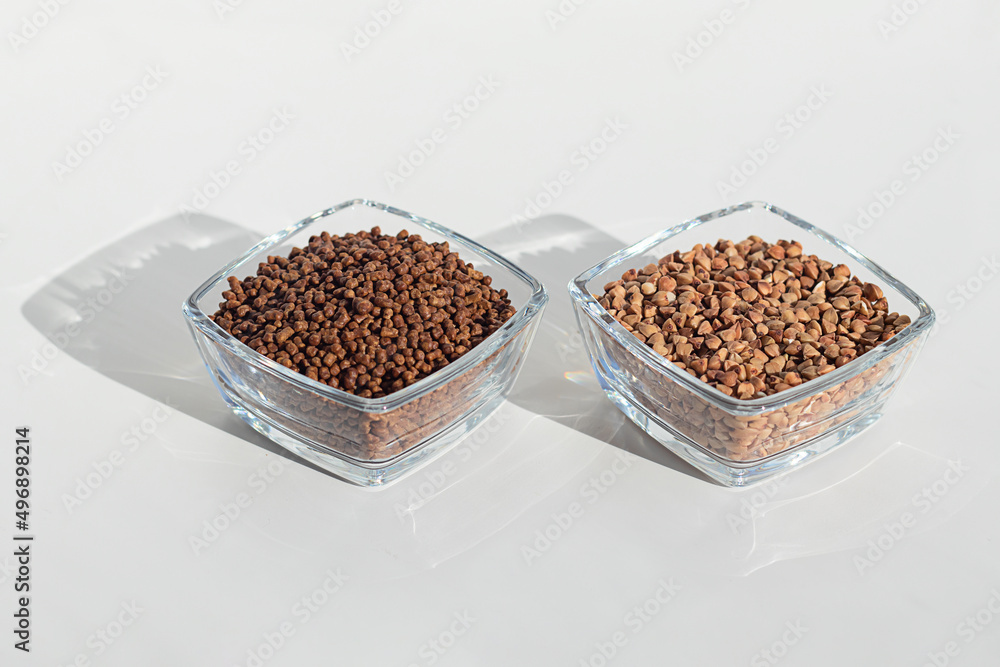 Close up of buckwheat tea granules and buckwheat groats in glass bowls on white background, natural herbal drink. Close up of buckwheat tea granules and buckwheat groats in glass bowls on white background, natural herbal drink.