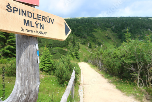 Sign Spindleruv Mlyn in Giant Mountains (Krkonose) with the tourist path in the background. Czech Republic, Bohemian Region.