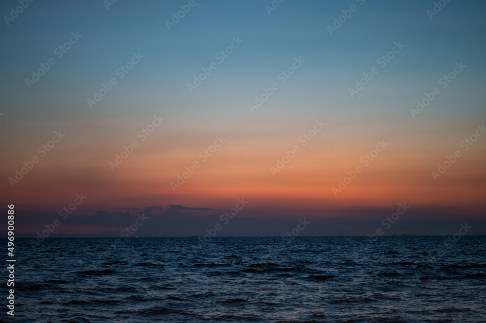 Obraz premium Beautiful sunset beach and light shining with waves breaking at Bang Saen Beach Chonburi province Thailand.