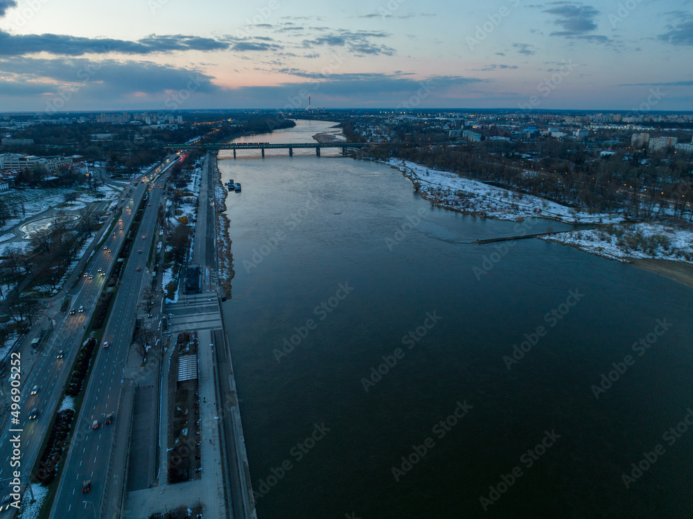 Duża rzeka widziana z drona podczas zachodu słońca, Warszawa, widoczne zabudowania i brzeg, mosty - obrazy, fototapety, plakaty 