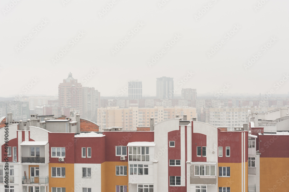 view from the window of a new building on the snow-covered roofs of houses in the old part of the foggy city view from the window of a new building on the snow-covered roofs of houses in the old part of the foggy city