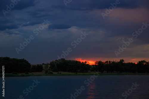 Sunset landscape before a thunderstorm. Evening river before rain during sunset.