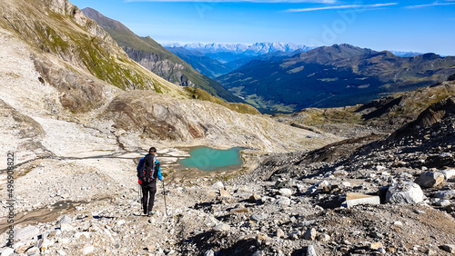 Hiking man with scenic view on Hoher Sonnblick in High Tauern mountains in Carinthia, Salzburg, Austria, Europe, Alps. Glacier lakes of Goldbergkees in Hohe Tauern National Park. Badgastein, Pongau