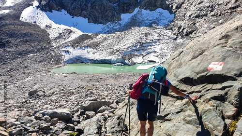 Hiking woman with scenic view on Hoher Sonnblick in High Tauern mountains in Carinthia, Salzburg, Austria, Europe, Alps. Glacier lakes of Goldbergkees in Hohe Tauern National Park. Patagonia landscape photo